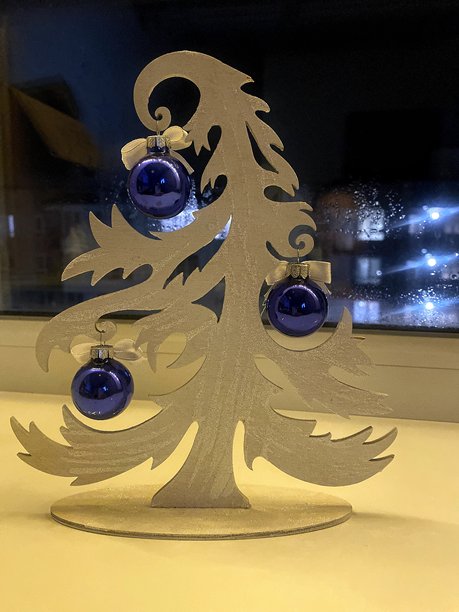 优雅的木制圣诞树，饰有蓝色挂件——节日餐桌装饰图片下载