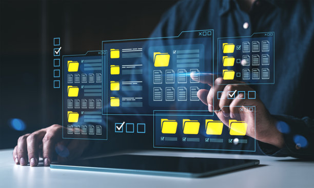 一名男子使用未来感数字界面，透明屏幕上显示着文件文件夹和文档，平板电脑置于下方，代表数据管理概念。图片下载