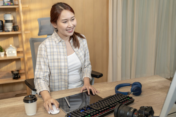 在家创意工作空间中编辑照片的自由职业女摄影师图片下载