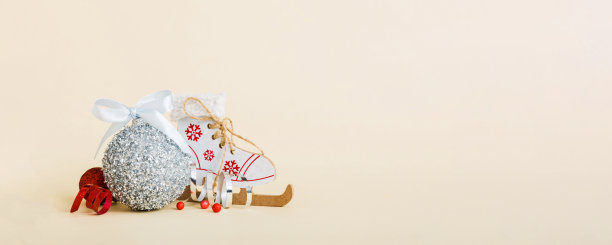 彩色背景上的圣诞装饰球和旱冰鞋。饰有丝带蝴蝶结的装饰球，并留有复制空间。图片下载