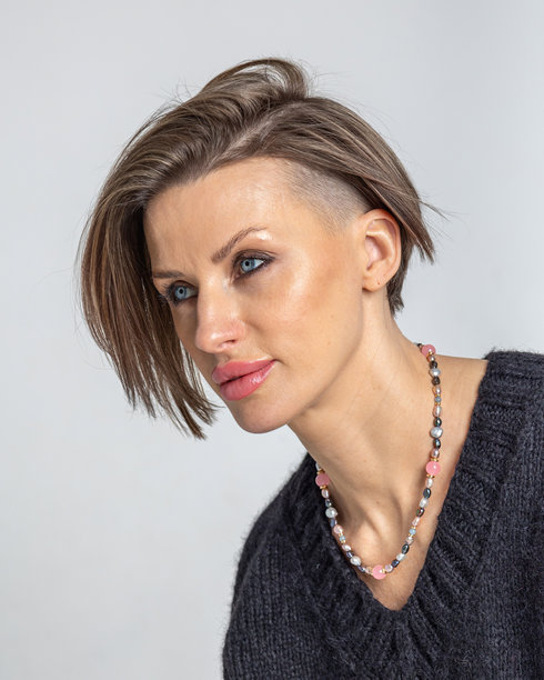 灰色背景下，年轻女子微笑的特写肖像。工作室摄影。竖版照片。图片下载