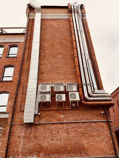 城市建筑维护，带通风口的风化墙壁，以暖通空调设备和磨损砖石为特色的城市景观，城市结构的外部显示着老化的砖石和冷却系统图片下载