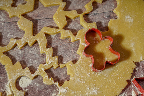 红色的雪人饼干模具放在待压的饼干面团上图片下载