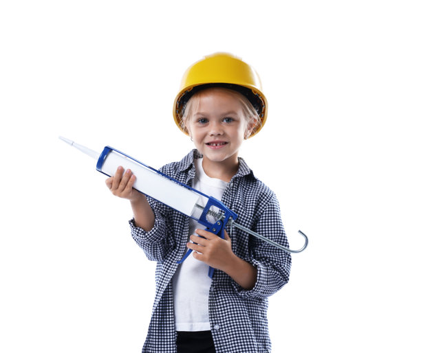 职业选择。小女孩戴着安全帽，拿着填缝枪，在白色背景上假装是建筑工人图片下载