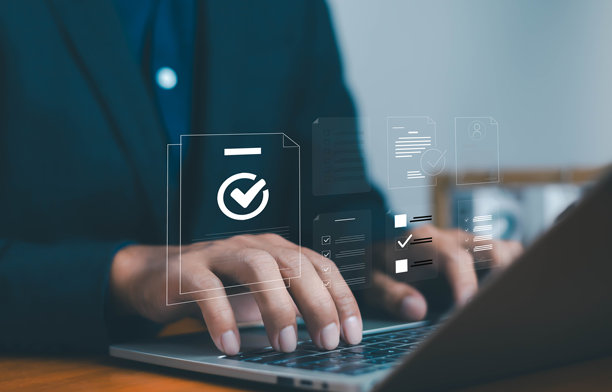 商务人士在笔记本电脑上打字，配有数字清单图标，象征着在线任务管理、工作流程自动化、生产力、数据组织以及用于提高效率的现代商业技术。图片下载