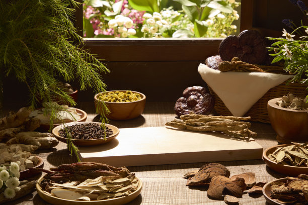 这张图片展示了散落在木桌上的干草药，背景虚化。自然光线，适合草本茶或药用品牌宣传。留有空白区域用于展示产品模型。图片下载
