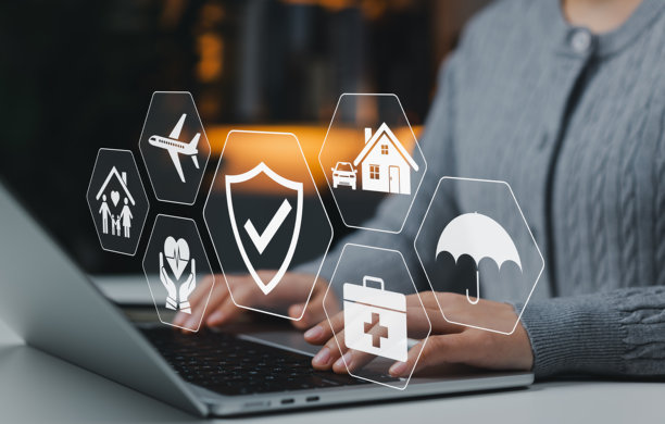 保险概念。一个人使用笔记本电脑，并配有健康、人寿、汽车、家庭、旅行、保障和家庭保险服务的图标。用于安全保障、保单管理、风险控制的数字平台。图片下载
