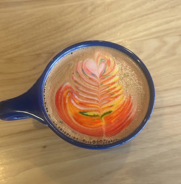 一杯精美的手工拿铁，浓郁的意式浓缩咖啡上覆盖着奶泡拉花。这张图片完美捕捉了经典咖啡馆体验的温馨和诱人之处，非常适合与咖啡相关的项目。图片下载