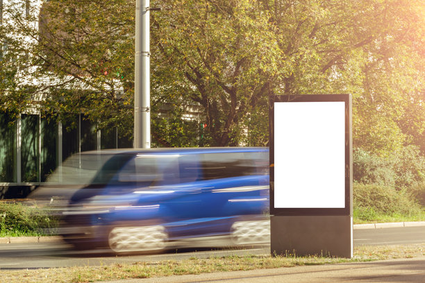 路边数字广告牌样机，带有空白白色屏幕和运动模糊的交通图片下载