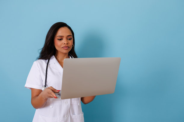 女医生手持笔记本电脑，在开发远程医疗解决方案和在线医疗技术时注视屏幕图片下载