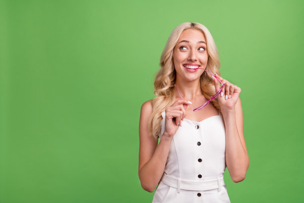 照片：一位面带微笑的美丽女子，手持游泳圈，享受着泳池派对的夏日周末，背景为绿色。图片下载