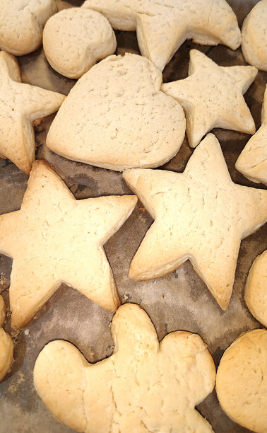 圣诞节手工饼干在木桌上烘焙。生面团、面粉、饼干模具展示了温馨的家庭烘焙。节日造型、家庭传统、冬季氛围和季节性美食的概念。图片下载