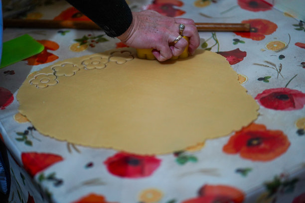 女人的手在家里的厨房用饼干模具在擀好的面团上操作图片下载