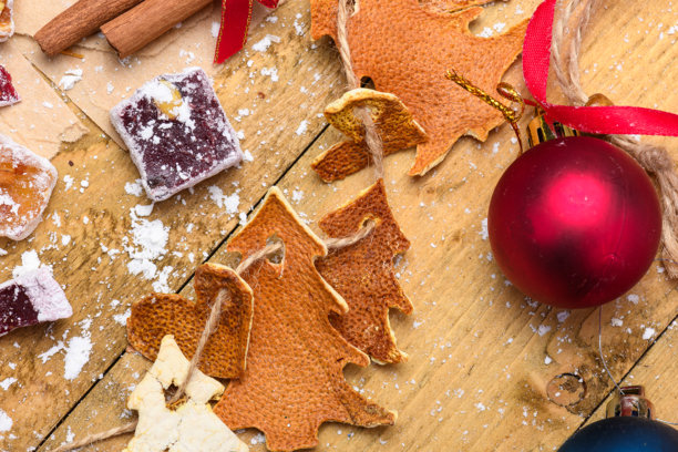 圣诞背景，饰有手工橙皮装饰、红色饰品和肉桂棒。图片下载
