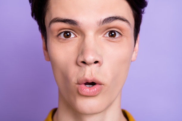 特写照片，一位印象深刻的棕色头发的千禧一代男性，孤立在紫色背景上图片下载