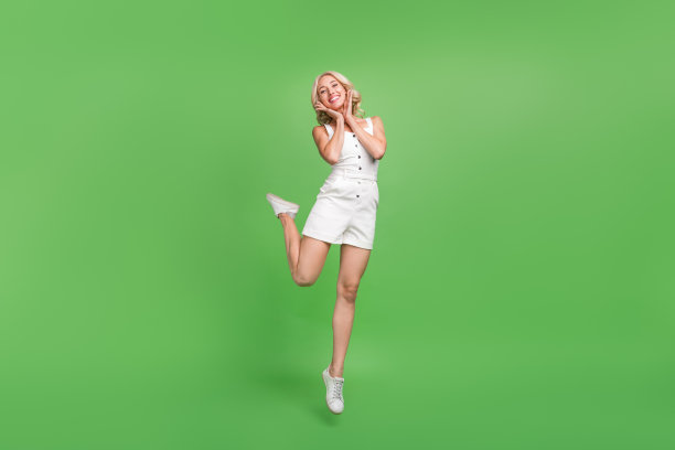 照片：一位带着笑容的美丽女性，手持游泳圈，在泳池派对上享受夏日周末，背景为绿色图片下载