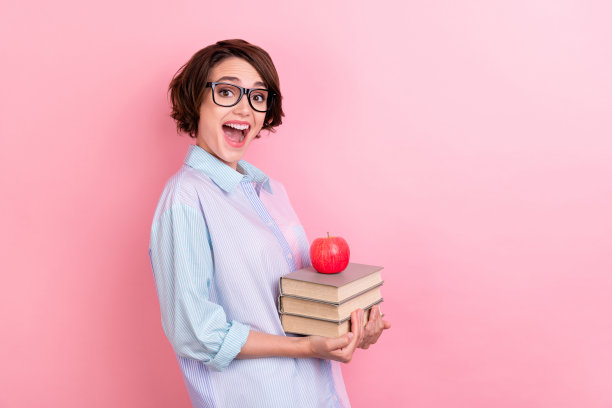 年轻女子侧面照片，带着快乐积极的微笑，兴奋的读者在柔和的彩色背景上学习知识、看书图片下载