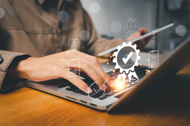 ISO标准质量控制、保证和保修业务技术概念。商人使用笔记本电脑，上面有质量保证和ISO文件图标，ISO概念。图片下载