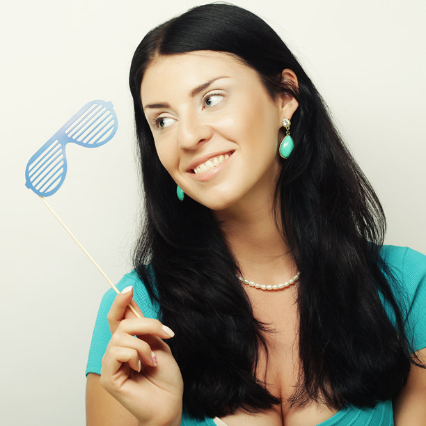 派对照片。调皮的年轻女子拿着派对眼镜。图片下载