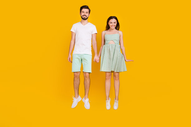 穿着休闲装的游客情侣手牵手在黄色背景下享受派对假期的照片图片下载