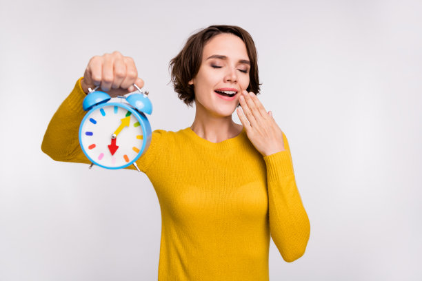 照片：一位留着棕色头发、身穿黄色衬衫的年轻女子，表情惊讶地看向空白处，背景为灰色图片下载