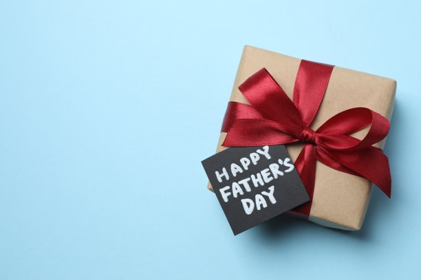 父亲节快乐扁平化概念。蓝色背景上带有丝带蝴蝶结的礼品盒的俯视照片图片下载