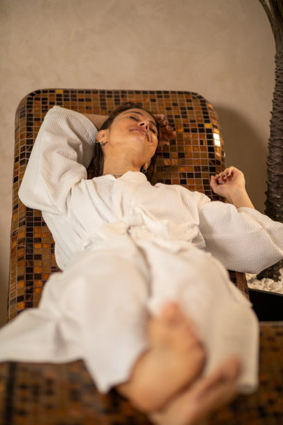 一位女性在养生水疗中心穿着浴袍放松。图片素材图片下载