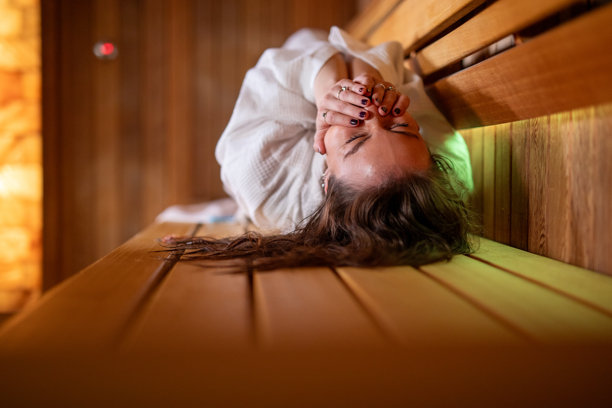 一位女士在木制桑拿房中享受热疗放松。素材图片图片下载