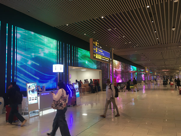 人们正带着有趣的LED显示屏走出行李提取区图片下载