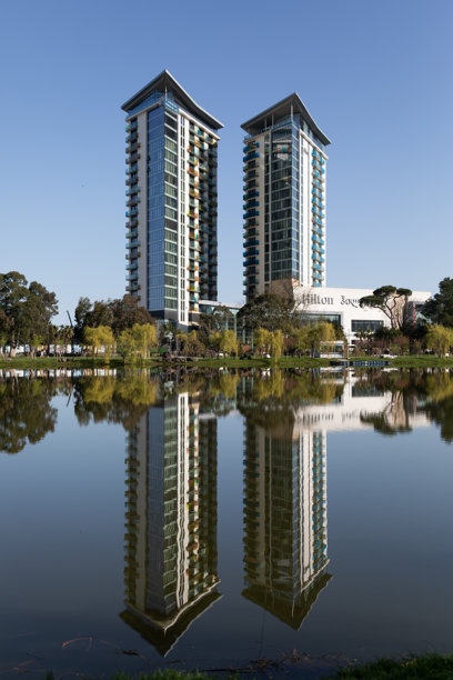 现代摩天大楼和湖滨公园的照片，水中有倒影图片下载