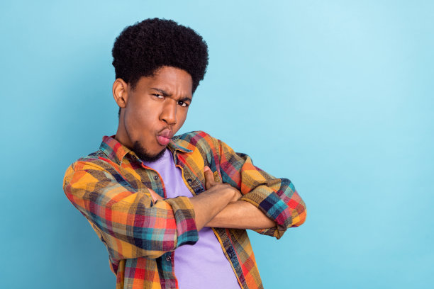 照片：身穿紫色T恤、大眼睛、肤色较深的帅气小伙子，表情惊讶，背景为蓝色。图片下载