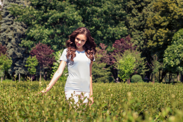 照片：一位快乐、可爱、充满梦想、积极的年轻女子在周末的户外公园里享受大自然并微笑图片下载