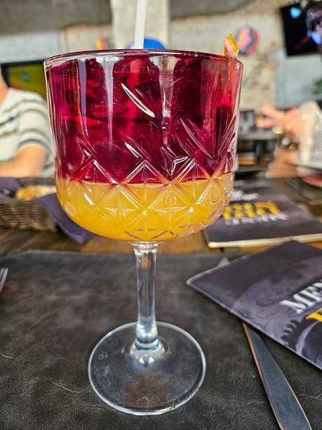 吧台背景下，优雅切面玻璃杯中盛着异国风情双色分层饮品图片下载