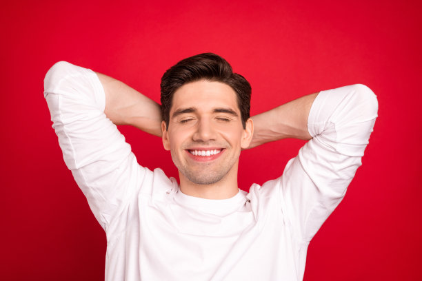 照片肖像：惊讶的棕发女子穿着休闲T恤，背景为明亮的红色，脸上洋溢着喜悦和快乐。图片下载
