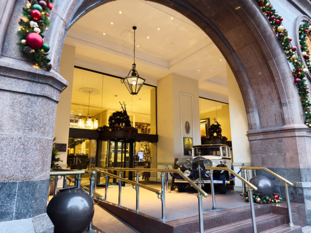 英国曼彻斯特一家酒店的大堂，圣诞节装饰精美，并陈列着一辆复古的劳斯莱斯汽车。图片下载