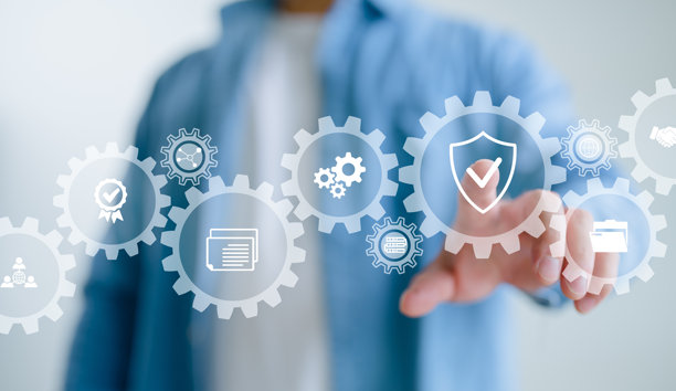 一个人在商务环境中，用齿轮和代表流程自动化及工作流管理的图标触摸数字屏幕。图片下载