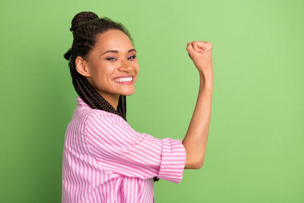 照片：穿着条纹粉色衬衫的兴奋开朗女子，张大嘴巴，脸上露出惊讶表情，背景为绿色。图片下载