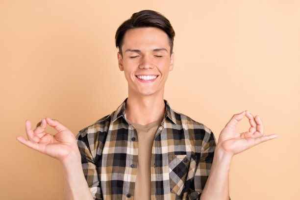 身穿格子衬衫的千禧一代帅气男性照片，在米色背景上孤立图片下载