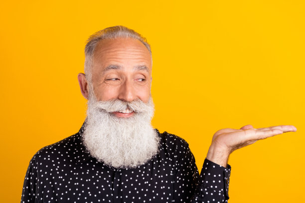 照片：一位迷人的老人在明亮的黄色背景上，带着怀疑的表情，仿佛在提问，引人入胜图片下载