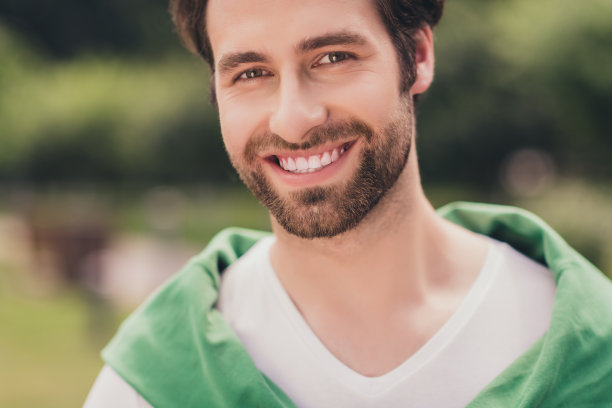 特写照片，年轻英俊、快乐、留着胡须的男人，带着阳光明媚的天气、季节和户外的灿烂笑容图片下载