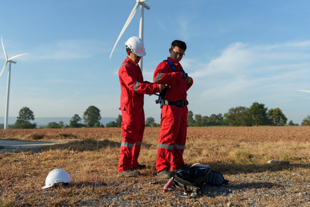工程师正在风力发电场检查风力涡轮机的运行情况并检测电力。(照片)图片下载