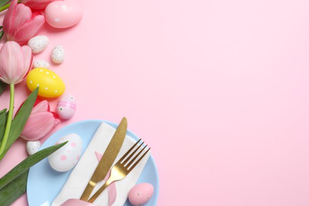 快乐复活节。彩色背景上的餐盘、餐具、彩蛋和郁金香的顶部照片，留有空白空间图片下载