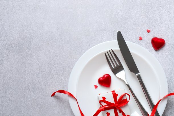 情人节概念。灰色背景下的餐盘、餐具、礼品盒和五彩纸屑的俯视照片，留有空白空间图片下载