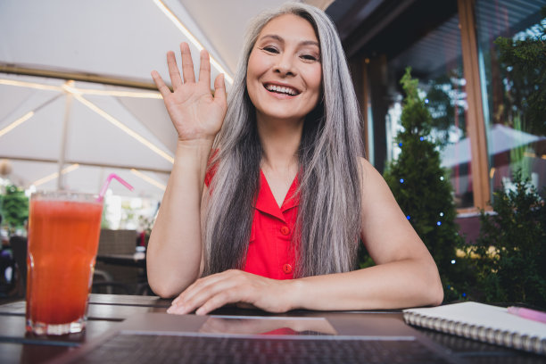 照片：一位成熟迷人的亚洲女性，面带快乐积极的微笑，在夏季户外市中心散步，享受假期旅行。图片下载