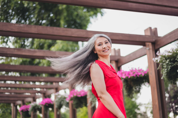 照片：一位成熟迷人的亚洲女性，面带快乐积极的微笑，在夏季户外市中心散步，享受假期旅行。图片下载