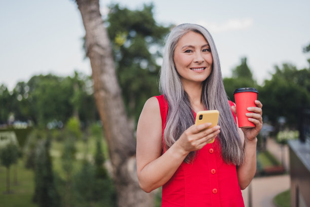 照片：一位成熟迷人的亚洲女性，带着开心的、积极的笑容，在夏季户外市中心散步，享受旅行度假的时光图片下载