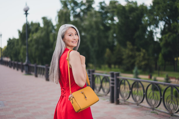 照片：一位成熟有魅力的亚洲女性，面带快乐积极的微笑，在夏日户外市中心旅行度假图片下载