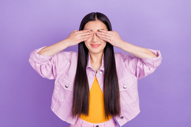 身穿粉色夹克的年轻棕发女士的个人资料照片，手持空白空间，孤立在紫色背景上图片下载