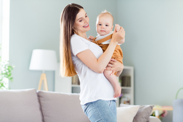 一位迷人的、善良的、深情的、开朗的女孩在家中抱着婴儿哺乳的照片，确保安全图片下载
