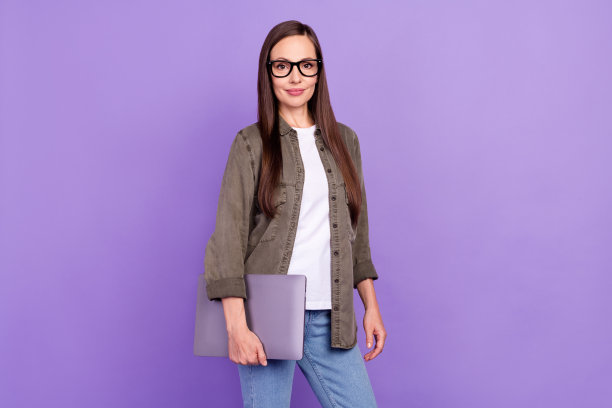 面带笑容、心情愉悦的女商人的全身照片，双手交叉，扮演老板或领导者角色，孤立在紫色背景上图片下载